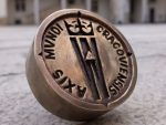 Osadzenie medalionu AXIS MVNDI CRACOVIENSIS na dziedzińcu Zamku Królewskiego na Wawelu.